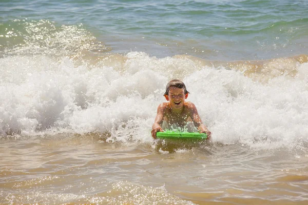 Симпатичный мальчик, занимающийся серфингом на волнах — стоковое фото