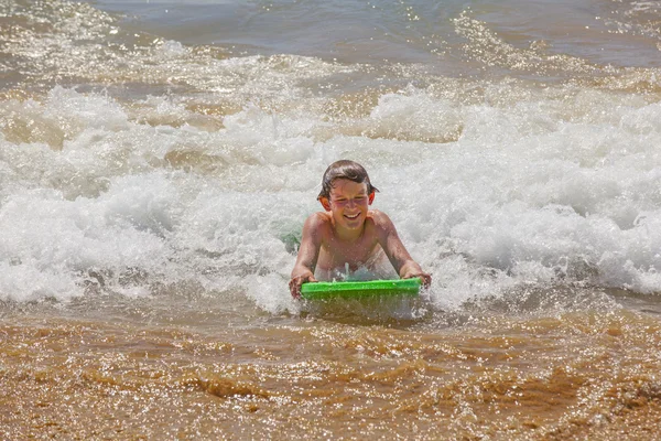 Χαριτωμένο αγόρι που σερφάρει στα κύματα — Φωτογραφία Αρχείου