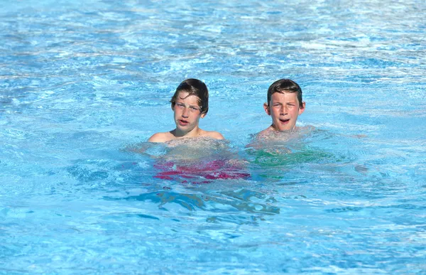 Irmãos brincando juntos na piscina — Fotografia de Stock