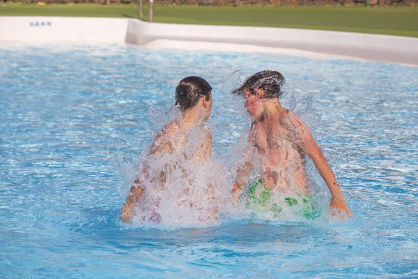 Irmãos brincando juntos na piscina — Fotografia de Stock
