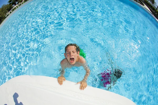 Мальчик плавает в бассейне — стоковое фото