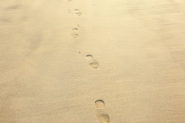 Lidské stopy v písku na pláži — Stock fotografie
