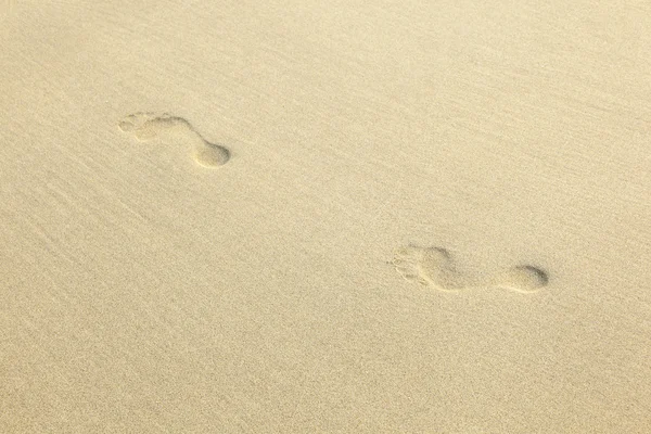Menselijke voetafdrukken in het zand op het strand — Stockfoto