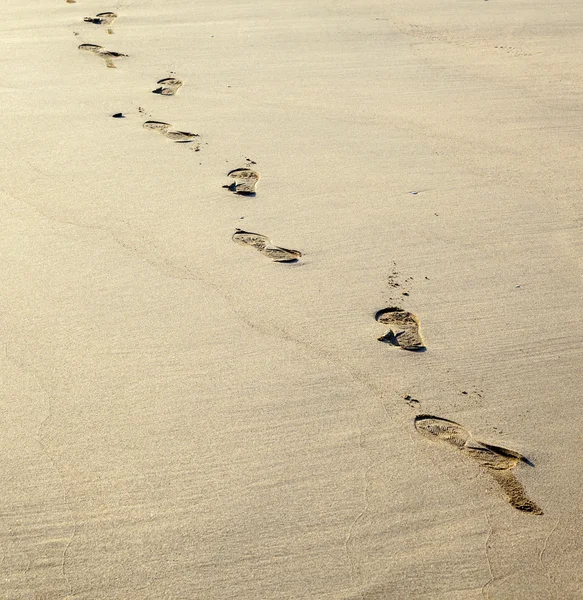 Lidské stopy v písku na pláži — Stock fotografie