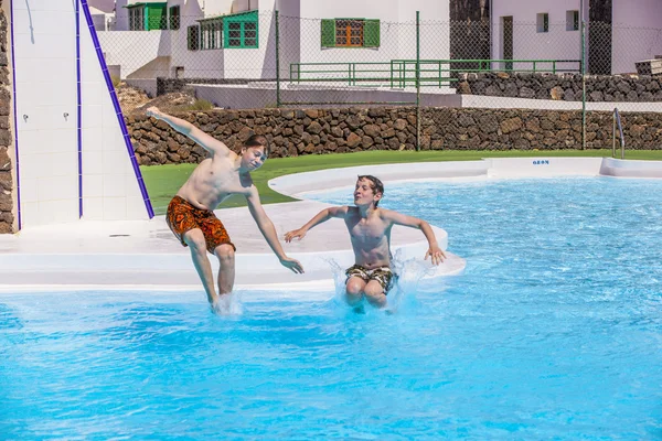 Мальчики прыгают в бассейн — стоковое фото