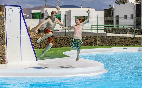 Rapazes a saltar para a piscina — Fotografia de Stock