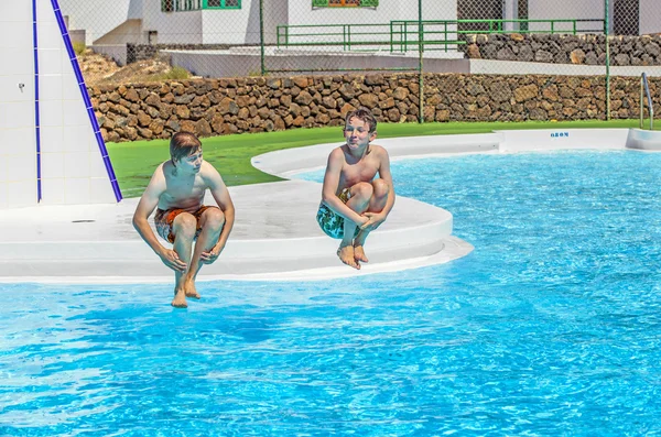 Två vänner hoppa i poolen — Stockfoto