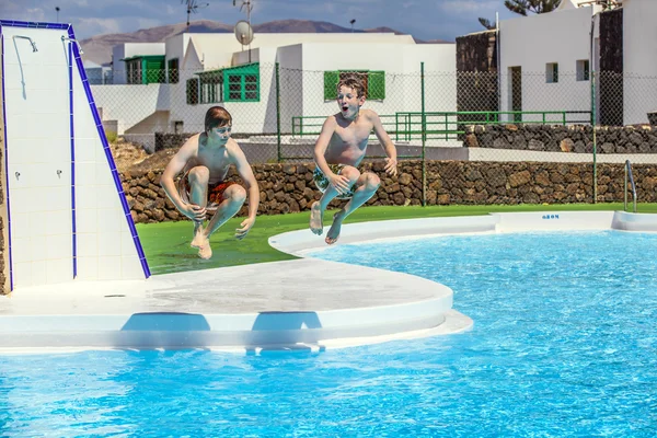Two friends jumping in the pool — Stock Photo, Image