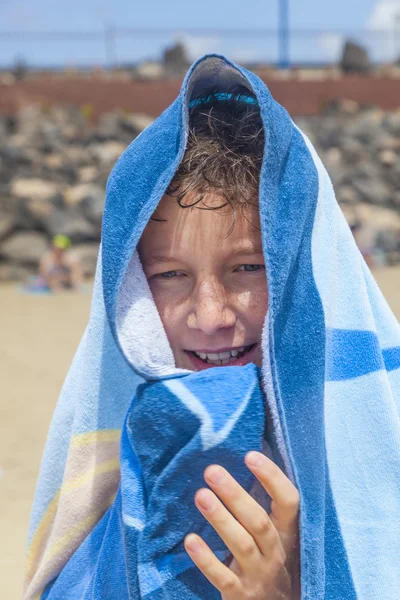 Menino feliz com toalha na praia — Fotografia de Stock