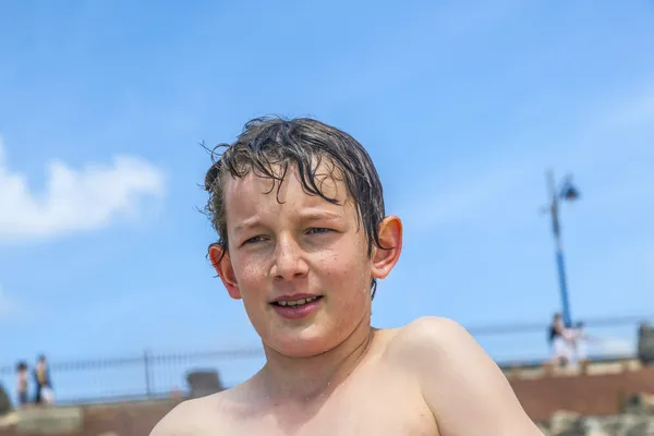 Menino feliz com toalha na praia — Fotografia de Stock