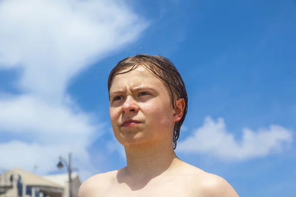 Portrait of smart boy against blue sky at the beach — Stock Photo, Image