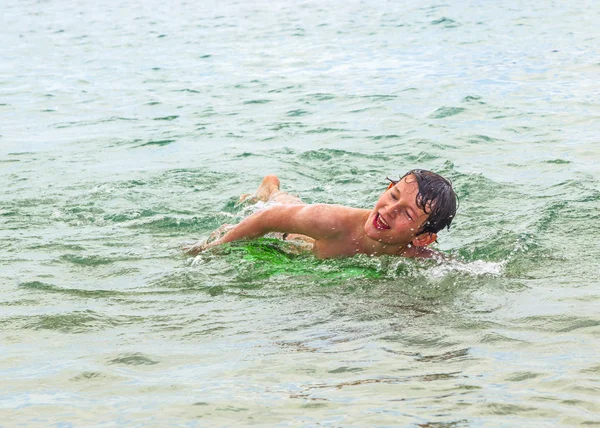 Feliz chico disfruta arrastrándose en el océano —  Fotos de Stock