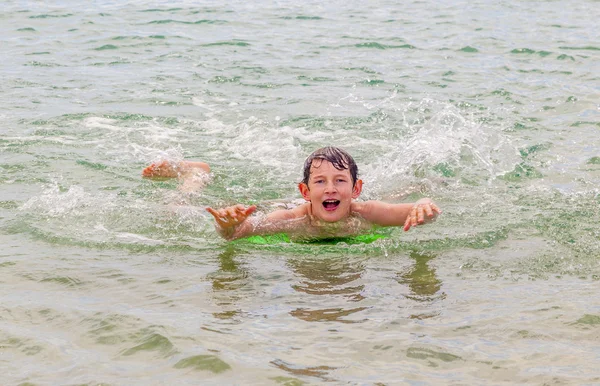 幸せな少年は波でのサーフィンを楽しんでいます。 — ストック写真