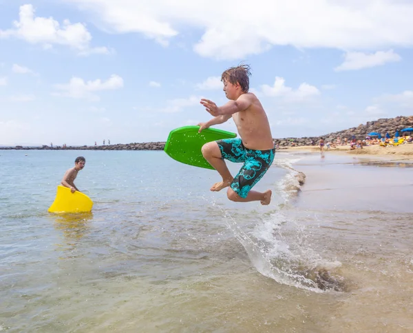 Boldog fiú élvezi a szörfözés a hullámok — Stock Fotó