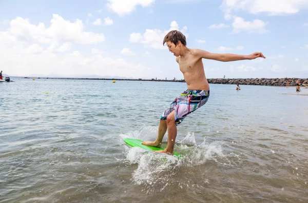 幸せな少年は波でのサーフィンを楽しんでいます。 — ストック写真