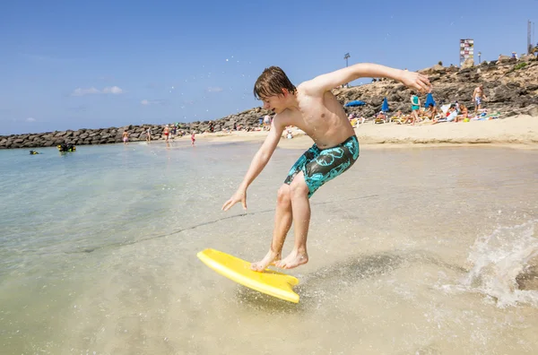 Glücklicher Junge genießt das Surfen in den Wellen — Stockfoto