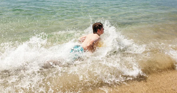 Glücklicher Junge genießt das Surfen in den Wellen — Stockfoto