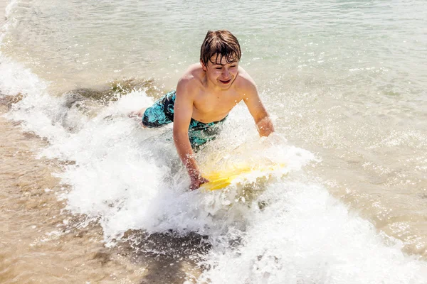 Щасливий хлопчик насолоджується серфінгом у хвилях — стокове фото