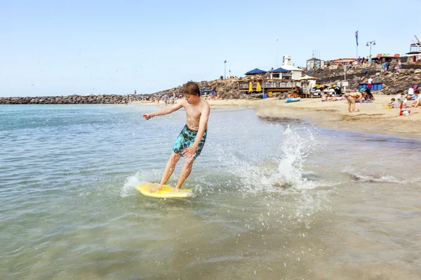 幸せな少年は波でのサーフィンを楽しんでいます。 — ストック写真