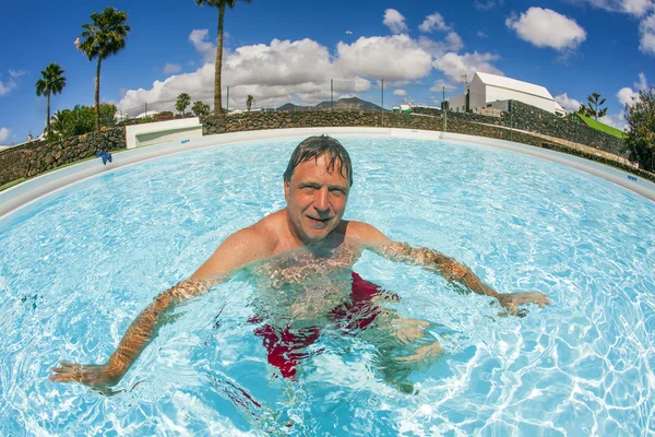Hombre atractivo disfruta nadando en la piscina —  Fotos de Stock