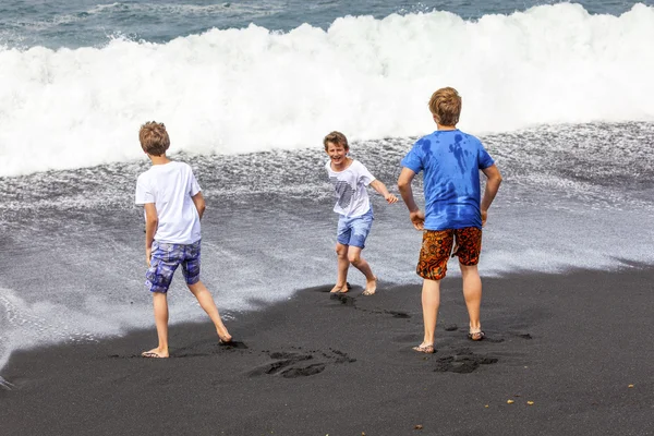 在黑色火山海滩男孩得开心 — 图库照片