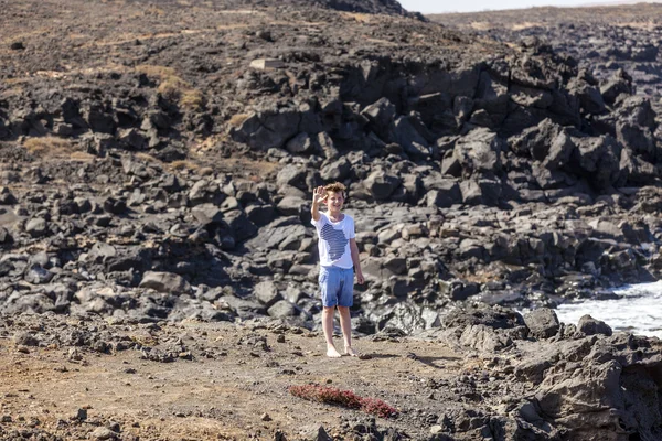 Pojke står på en klippa — Stockfoto