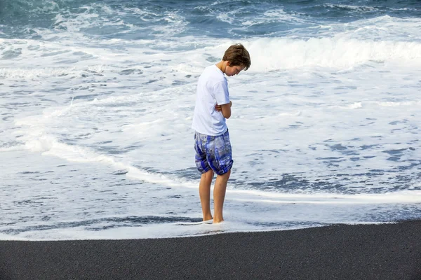 Rapaz observa a lama do oceano — Fotografia de Stock