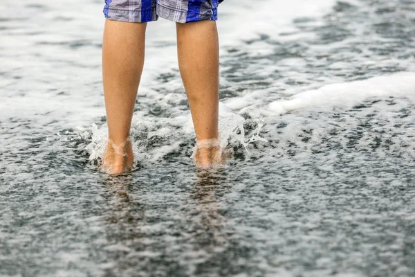 Fötter av pojke på stranden — Stockfoto