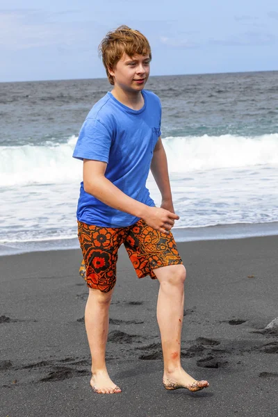 男の子は黒い火山ビーチで楽しい時を過す — ストック写真