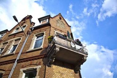 Balcony of old brick house with blue sky clipart