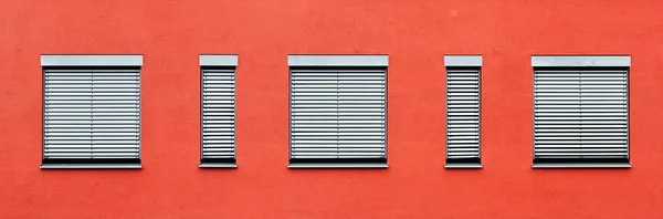 Узор окон с красной стеной — стоковое фото
