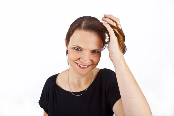 Attrayant jeune femme sourit et joue avec ses cheveux — Photo