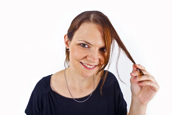 Приваблива молода жінка посміхається і грає з волоссям — стокове фото