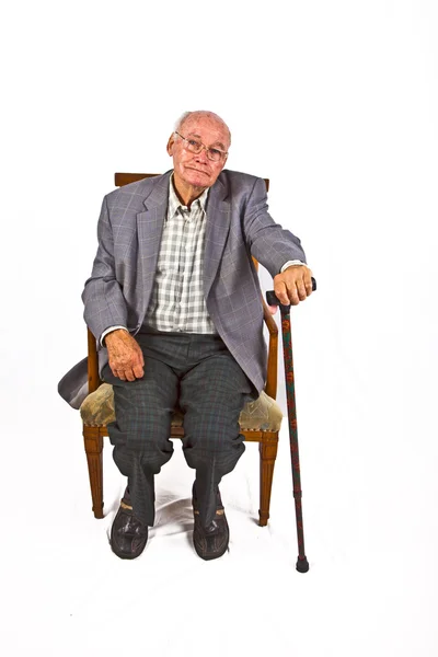 Vieil homme amical assis dans son fauteuil avec bâton de marche — Photo