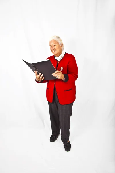 Aantrekkelijke oudere lachende vrouw in een boek lezen en het maken van een — Stockfoto