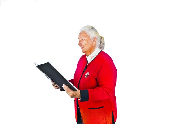 Smiling attractive elderly woman reading in a book and making a — Stock Photo, Image