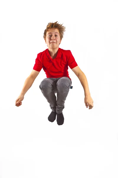 Счастливый мальчик в красной рубашке прыгает — стоковое фото