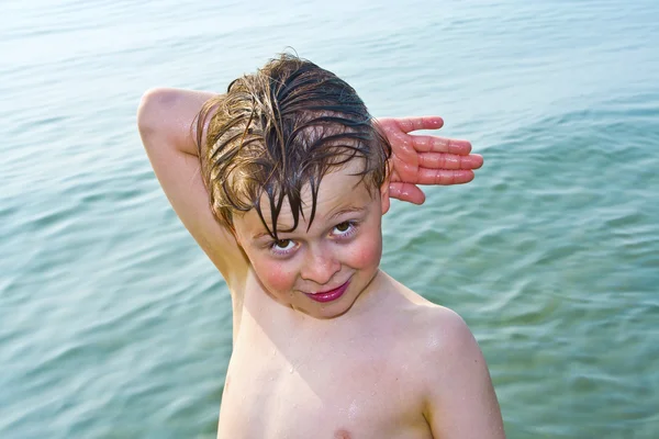 Aranyos fiú pózol a víz a strand Velence, Olaszország. — Stock Fotó