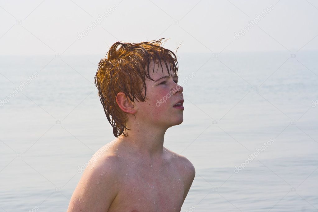 Cute boy standing in the water of the beach in Venice, Italy.