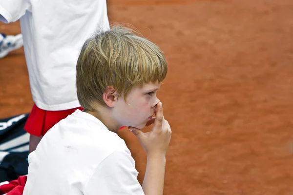 Хлопчик відпочиває між тенісними матчами — стокове фото