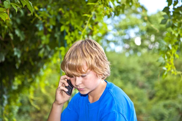 年轻的男孩谈一部手机. — 图库照片