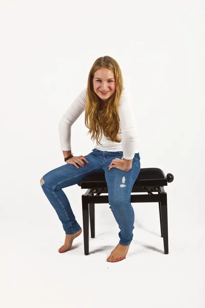 Full length portrait of happy beautiful girl sitting on a piano — Stock Photo, Image