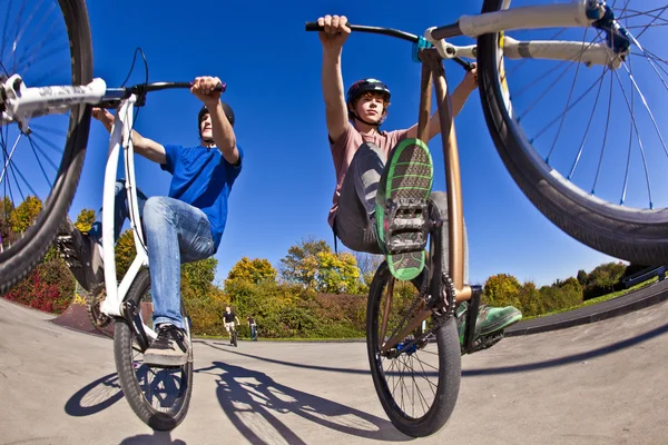 Boys show double wheely with the bike — Zdjęcie stockowe