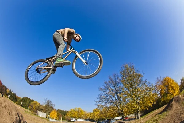 Мальчик летит по воздуху на грязном велосипеде — стоковое фото