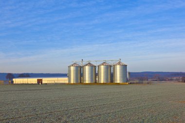 Silos in the middle of a field in wintertime clipart