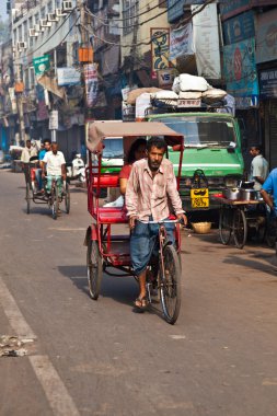 Cycle rickshaw driver with passenger in Chawri Bazar, Delhi earl clipart