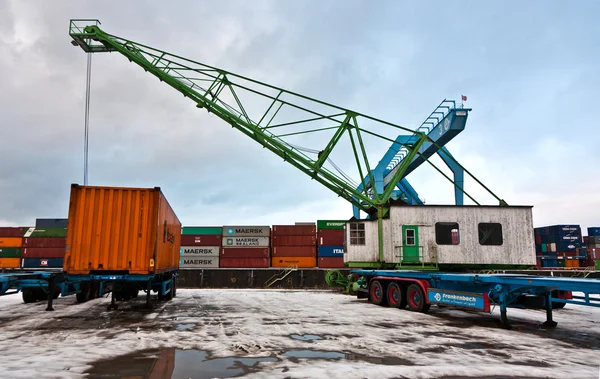 Кран и контейнер в контейнерной гавани зимой — стоковое фото