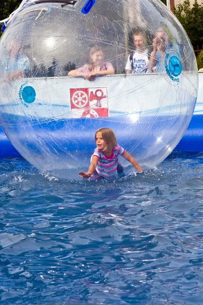 Girls and boys have fun in a huge zorbing ball — Stock Photo, Image