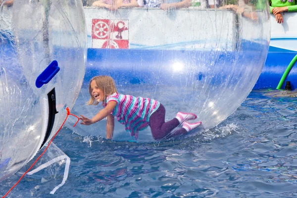 Girls and boys have fun in a huge zorbing ball — Stock Photo, Image