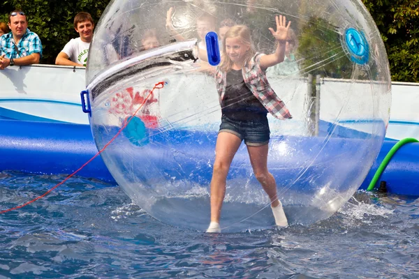 Lányok és fiúk szórakozni egy hatalmas zorbing labda — Stock Fotó